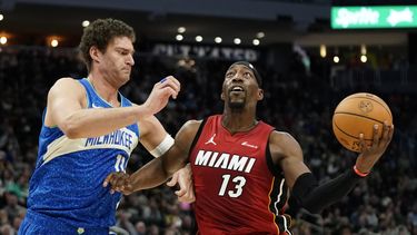 Bam Adebayo (13) del Heat de Miami conduce hacia el aro ante Brook Lopez de los Bucks de Milwaukee durante la 1ra mitad del juego de baloncesto de la NBA, el martes 13 de febrero de 2024. (AP Foto/Aaron Gash)