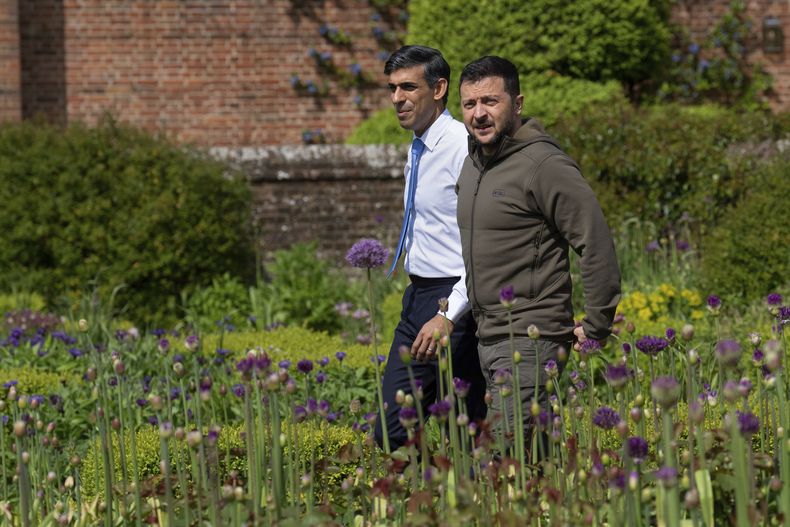 El primer ministro británico, Rishi Sunak, a la izquierda, y el presidente de Ucrania, Volodymyr Zelenskyy, caminan por el jardín en Chequers, la residencia oficial de campo del primer ministro británico en Aylesbury, Inglaterra, el lunes 15 de mayo de 2023. Volodymyr Zelenskyy ha cruzado Europa con una larga lista de la compra. El presidente de Ucrania regresará a casa con muchas de las cosas que quería, pero no los cazas occidentales que buscaba para defenderse de los ataques aéreos rusos. (Carl Court/Pool via AP)