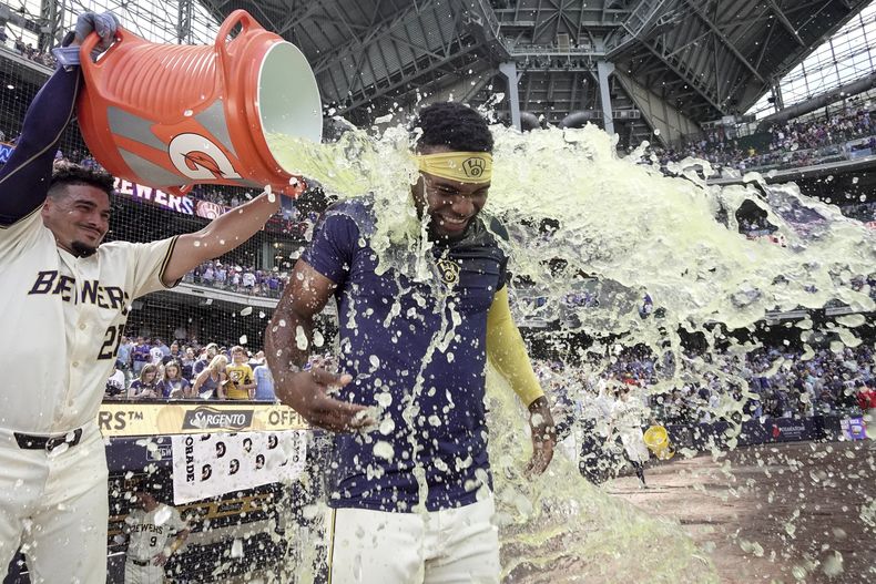 Andruw Monasterio de los Cerveceros de Milwaukee es bañado por su compañero Willy Adames tras batear un sencillo remolcador en la décima frente a los Rangers de Texas el miércoles 26 de junio del 2024. (AP Foto/Morry Gash)