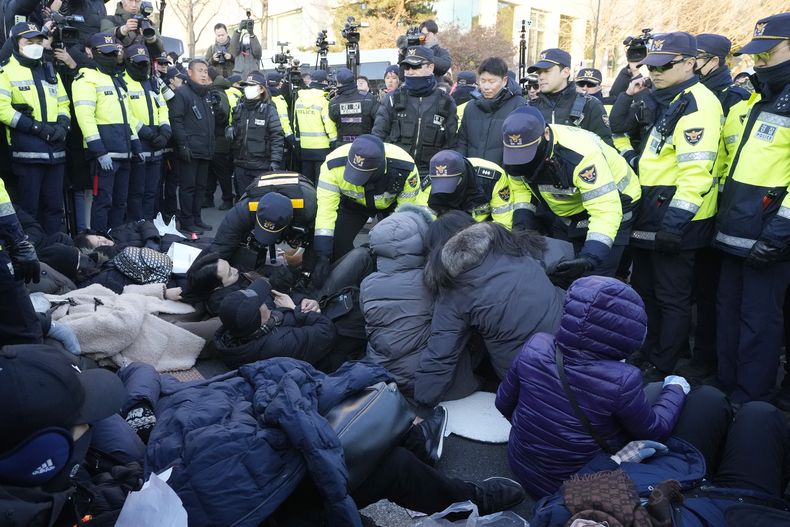 Agentes de la policía arrastran a simpatizantes del presidente suspendido surcoreano, Yoon Suk Yeol, cerca de la residencia presidencial el jueves 2 de enero de 2025, en Seúl, Corea del Sur. (AP Foto/Ahn Young-joon)