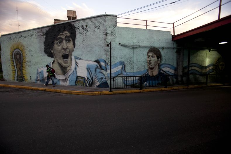 Imagen de los futbolistas argentinos Diego Maradona, izquierda, y Lionel Messi, pintadas en un muro en el barrio El Once en Buenos Aires, el lunes, 2 de diciembre de 2013. (AP Photo/Natacha Pisarenko)