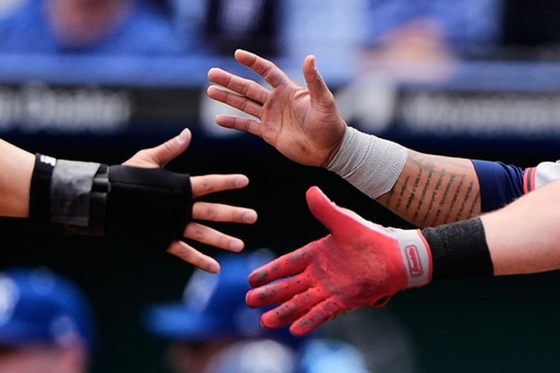 Steven Kwan celebra con sus compañeros de los Guardianes de Cleveland José Ramírez y Daniel Schneemann tras anotar en un doble de dos carreras de Kyle Manzardo en la primera entrada ante los Reales de Kansas City el jueves 7 de mayo del 2026. (AP Foto/Charlie Riedel)