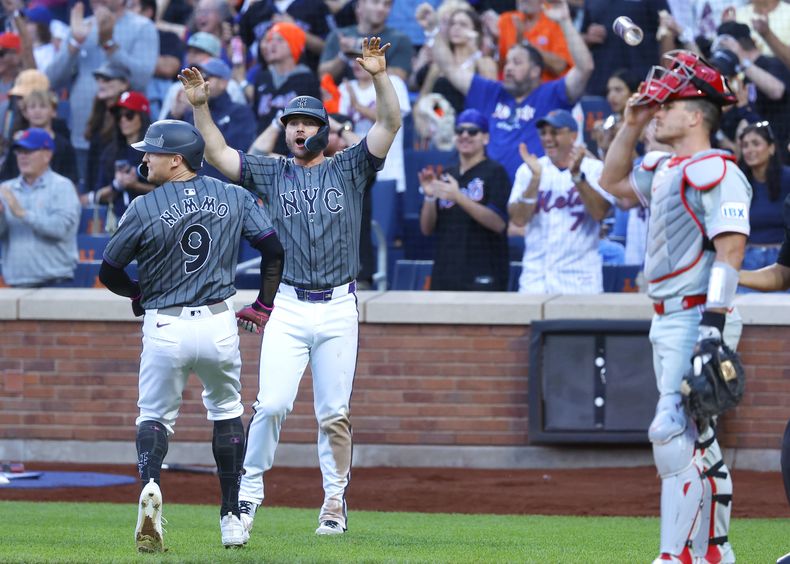 Pete Alonso, segundo desde la izquierda, y Brandon Nimmo (9), de los Mets de Nueva York, reaccionan tras anotar con un doble de Francisco Álvarez durante la séptima entrada el sábado 21 de septiembre de 2024, en Nueva York. (AP Foto/Noah K. Murray)
