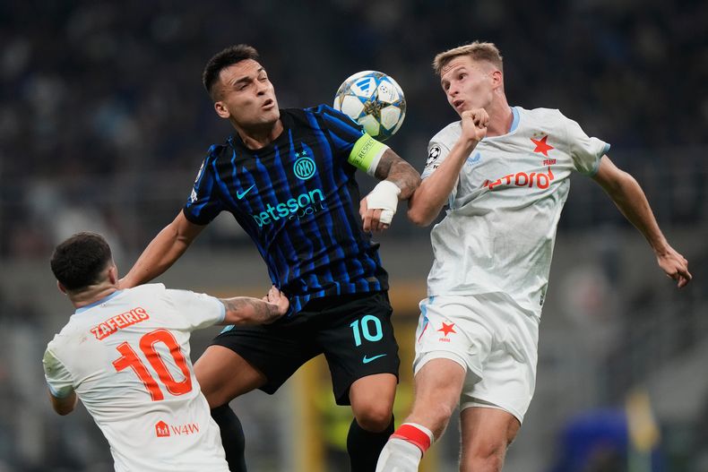 Lautaro Martínez (centro) del Inter de Milán pugna el balón con David Zima de Slavia Praga, en el partido de la Liga de Campeones, el martes 30 de septiembre de 2025, en Milán. (AP Foto/Luca Bruno)