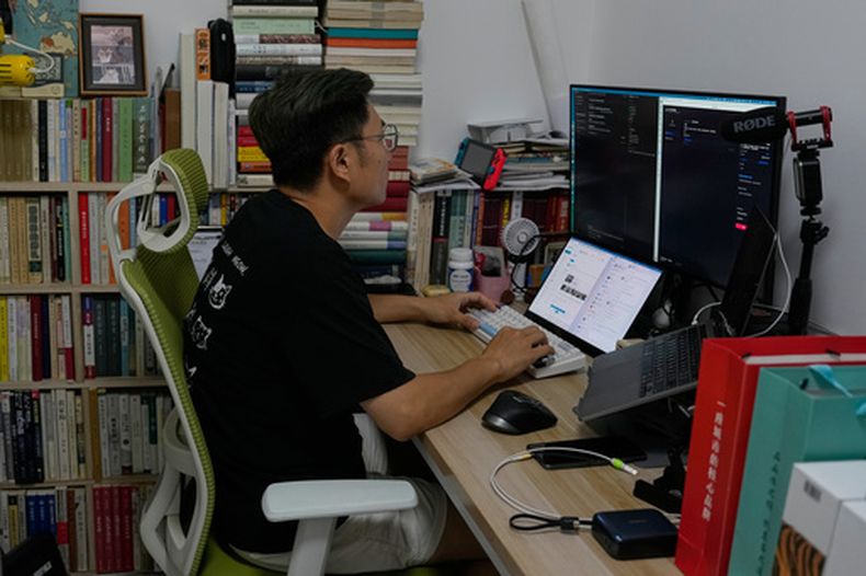 Fei Zhaojun, quien fuera ingeniero de software, trabaja en la computadora de su residencia, el 13 de julio de 2026, en Beijing. (AP Foto/Andy Wong)