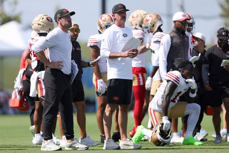 Kyle Shanahan, centro, entrenador en jefe de los 49ers de San Francisco, observa la práctica conjunta con los Chargers de Los Ángeles, el martes 18 de agosto de 2026, en El Segundo, California. (AP Foto/Ryan Sun)
