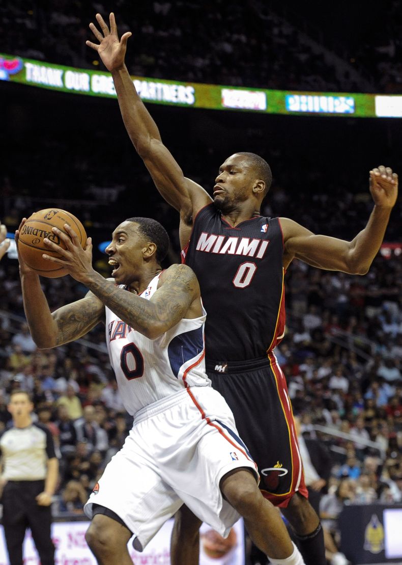 Jeff Teague, de los Hawks de Atlanta, salta hacia la cesta frente a Toney Douglas, del Heat de Miami, en el encuentro del s&aacute;bado 12 de abril de 2014 (AP foto/John Amis)