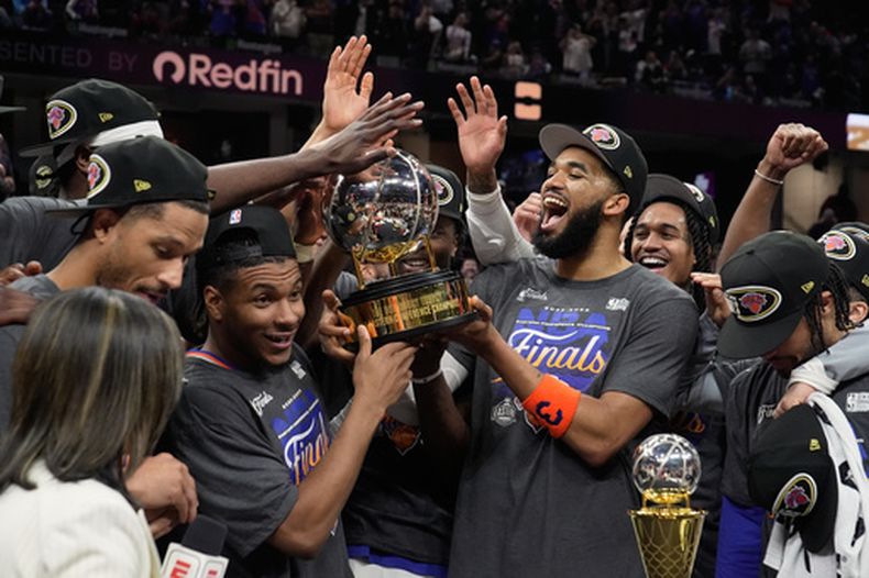 Los jugadores de los Knicks de Nueva York, sostienen el trofeo de la Conferencia Este después de ganar el cuarto juego de las finales y barrer a los Cavaliers de Cleveland, el lunes 25 de mayo de 2026, en Cleveland. (AP Foto/Sue Ogrocki)