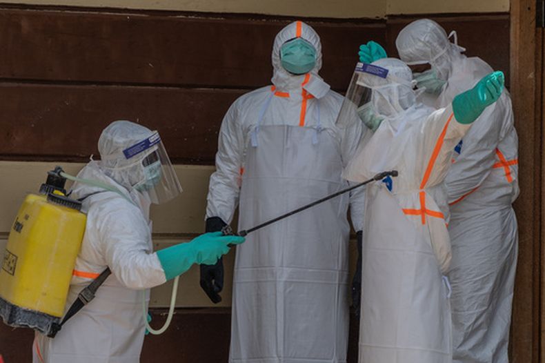 Trabajadores de salud se desinfectan tras preparar el cuerpo de una víctima de ébola en la clínica Citadelle en Bunia, República Democrática del Congo, el viernes 12 de junio de 2026. (AP Foto/Moses Sawasawa)