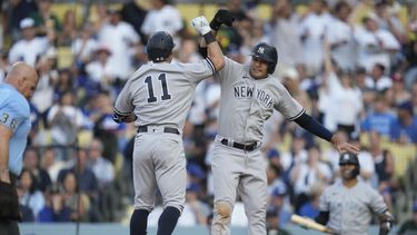 Anthony Volpe (11), de los Yanquis de Nueva York, celebra con Isiah Kiner-Falefa (12) después de que ambos anotaron con cuadrangular de Volpe durante la novena entrada del juego de béisbol en contra de los Dodgers de Los Ángeles, en Los Ángeles, el domingo 4 de junio de 2023. (AP Foto/Ashley Landis)