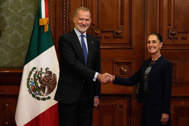 El rey Felipe VI de España y la presidenta mexicana Claudia Sheinbaum posan para una fotografía dándose la mano durante una ceremonia de bienvenida en el Palacio Nacional de la Ciudad de México, el jueves 25 de junio de 2026. (AP Foto/Marco Ugarte)