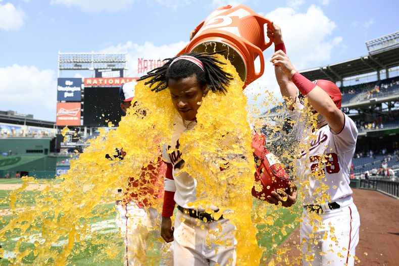 CJ Abrams (centro) de los Nacionales de Washington recibe un baño de Gatorade tras la victoria ante los Rockies de Colorado, el miércoles 26 de julio de 2023, en Washington. (AP Foto/Nick Wass)
