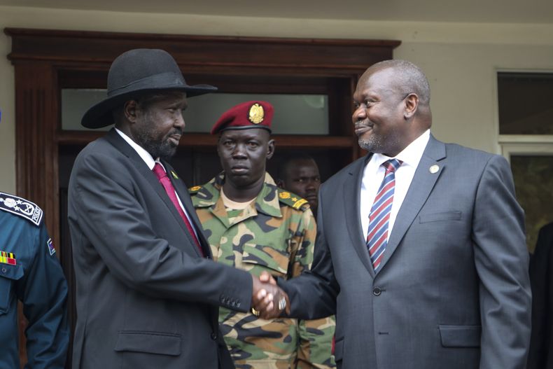 ARCHIVO -El presidente de Sudán del Sur, Salva Kiir (izquierda), y el vicepresidente, Riek Machar (derecha), se estrechan la mano tras una reunión en Yuba, Sudán del Sur, el 20 de octubre de 2019, para discutir detalles del acuerdo de paz. (AP Foto/Sam Mednick, archivo)