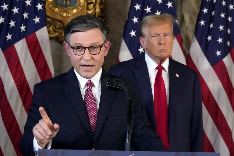 El presidente de la Cámara de Representantes, el republicano Mike Johnson, al frente, y el expresidente Donald Trump, al fondo, durante una conferencia de prensa, el 12 de abril de 2024, en Mar-a-Lago, en Palm Beach, Florida. (AP Foto/Wilfredo Lee)