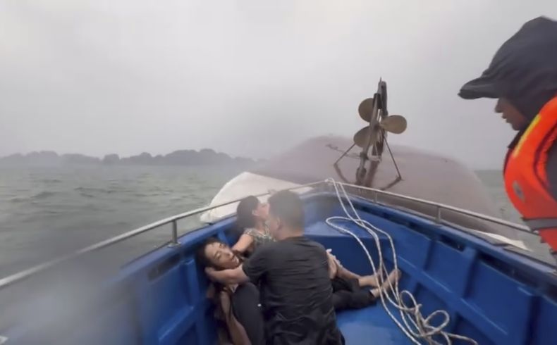 Esta imagen de un video proporcionado por QDND muestra a personas en un bote de rescate después de que su barco turístico volcara en la bahía de Ha Long, Vietnam, el sábado 19 de julio de 2025. (QDND vía AP)