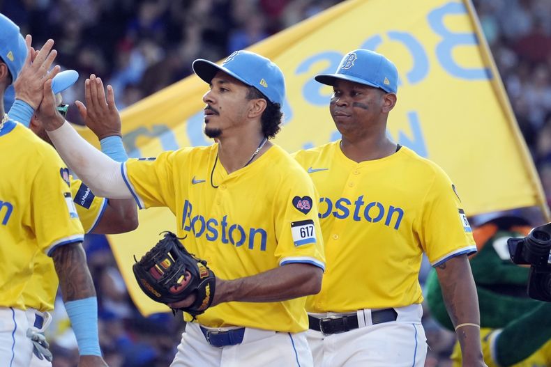 David Hamilton, a la izquierda, y Rafael Devers, a la derecha, de los Medias Rojas de Boston, celebran después de derrotar a los Reales de Kansas City, el sábado 13 de julio de 2024, en Boston. (AP Foto/Michael Dwyer)