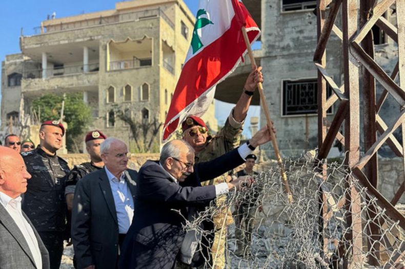 En esta imagen publicada por la oficina de prensa del gobierno libanés, el primer ministro de Líbano, Nawaf Salam, en el centro, izan una bandera libanesa durante una visita al pueblo sureño de Zawtar Al Gharbieh, Líbano, el miércoles 22 de julio de 2026. (Oficina de prensa del gobierno libanés via AP)