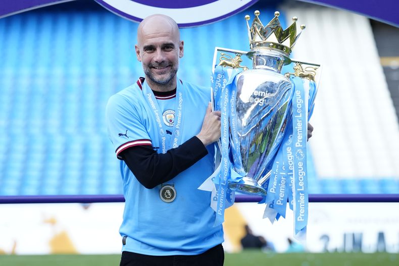 El técnico del Manchester City, Pep Guardiola, posa con el trofeo de la Liga Premier tras el partido contra Chelsea, el domingo 21 de mayo de 2023, en Manchester. (AP Foto/Jon Super)