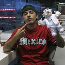 El rapero argentino Trueno posa con un muñeco de Dr. Simi después de lanzar la primera bola del partido entre los Diablos Rojos del México y el Águila de Veracruz en la Ciudad de México el jueves 2 de mayo de 2024.(Foto AP/Berenice Bautista)