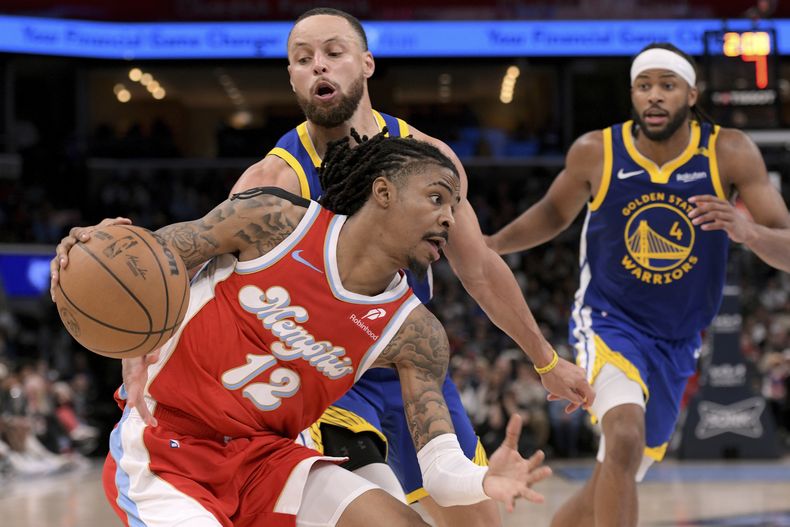 Ja Morant (12) de los Grizzlies de Memphis conduce el balón ante Stephen Curry de los Warriors de Golden State, el martes 1 de abril de 2025, en Memphis. (AP Foto/Brandon Dill)