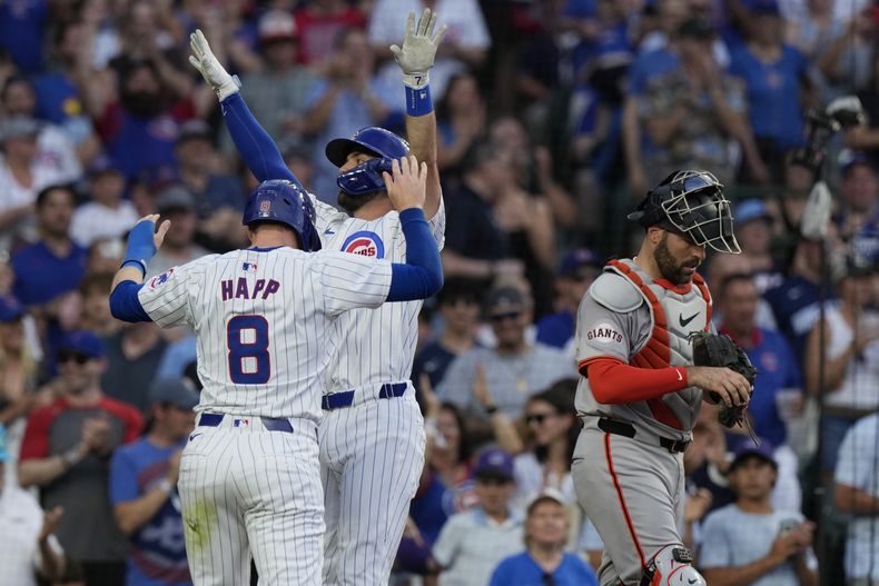 Ian Happ y Dansby Swanson, de los Cachorros de Chicago, festejan luego que el segundo conectó un jonrón en el duelo ante los Gigantes de San Francisco, el martes 18 de junio de 2024 (AP Foto/Nam Y. Huh)