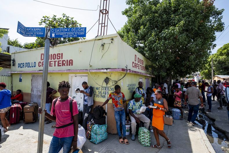 Varias personas custodian bolsas llenas de mercancía que adquirieron en Dajabón, República Dominicana, el jueves 14 de septiembre de 2023, antes de cruzar la frontera para regresar a Haití. (AP Foto/Ricardo Hernández)