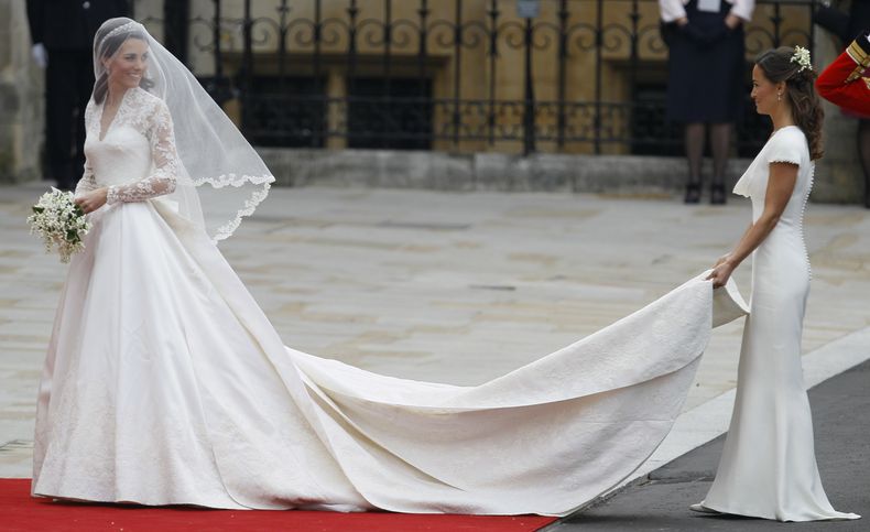 ARCHIVO - Kate Middleton, a la izquierda, y acompañada por la dama de honor Pippa Middleton a su llegada a la Abadía de Westminster para su boda real en Londres el viernes 29 de abril de 2011. La atención sobre la princesa Catalina ha alcanzado niveles no vistos desde que se casó con el príncipe Guillermo en una boda de cuento de hadas en 2011. La admisión de que Catalina alteró una fotografía familiar oficial provocó una reacción violenta. (Foto AP/Alastair Grant, archivo)