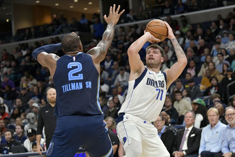 Luka Doncic (77), de los Mavericks de Dallas, dispara ante la presión de Xavier Tillman (2), de los Grizzlies de Memphis, en la segunda mitad del juego de baloncesto de la NBA, el lunes 30 de octubre de 2023, en Memphis, Tennessee. (AP Foto/Brandon Dill)