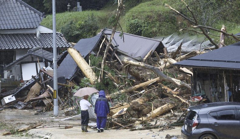 Gente ante los restos de un alud de lodo tras una tormenta en Ayabe, en la prefectura de Kioto, en el oeste de Japón el martes 15 de agosto de 2023. (Kyodo News via AP)