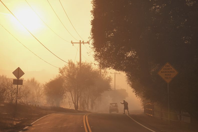 Un residente para un auto mientras los residentes desalojan las inmediaciones del incendio del Cañón, el 7 de agosto de 2025, en el Cañón Hasley, California. (AP Foto/Marcio José Sánchez)