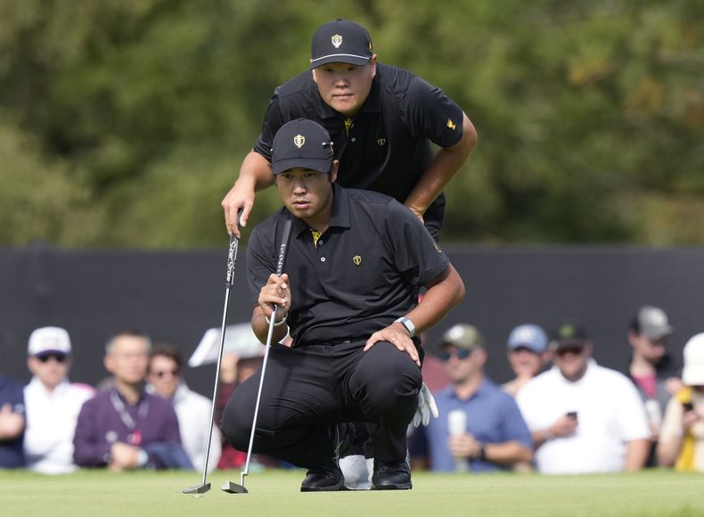 El japonés Hideki Matsuyama (adelante) y el surcoreano Sungjae Im calculan un putt en el hoyo 8, durante la Copa Presidentes, el viernes 27 de septiembre de 2024 (Frank Gunn/The Canadian Press via AP)