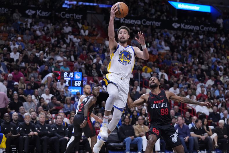 Klay Thompson, de los Warriors de Golden State, salta para encestar frente a Patty Mills, del Heat de Miami, en el encuentro del martes 26 de marzo de 2024 (AP Foto/Wilfredo Lee)