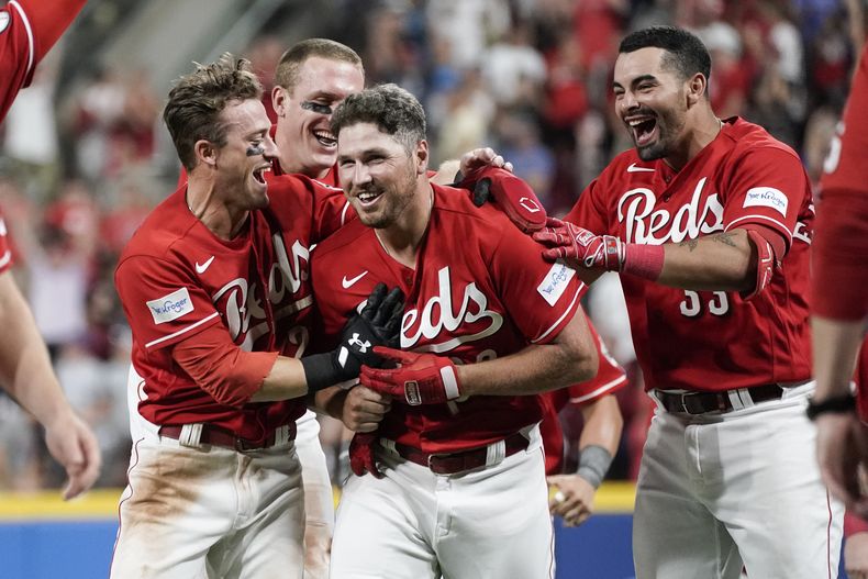 Hunter Renfroe (centro), de los Rojos de Cincinnati, festeja con sus compañeros tras empujar la carrera del triunfo sobre los Cachorros de Chicago, el sábado 2 de septiembre de 2023 (AP Foto/Joshua A. Bickel)