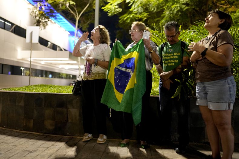 Simpatizantes rezan por la salud del expresidente brasileño Jair Bolsonaro después de ser trasladado a un hospital con dolor abdominal en Brasilia, Brasil, el sábado 12 de abril de 2025. (AP Foto/Eraldo Peres)