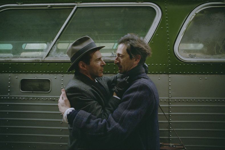 Esta imagen difundida por A24 muestra a Alessandro Nivola, izquierda, y Adrien Brody en una escena de The Brutalist. (A24 via AP)
