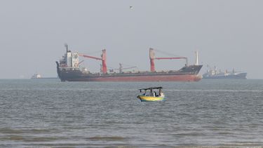 Una embarcación pequeña navega por el estrecho de Ormuz, con buques comerciales anclados de fondo, frente a la costa de Bandar Abbas, Irán, el 13 de octubre de 2026. (Razieh Poudat/ISNA via AP)