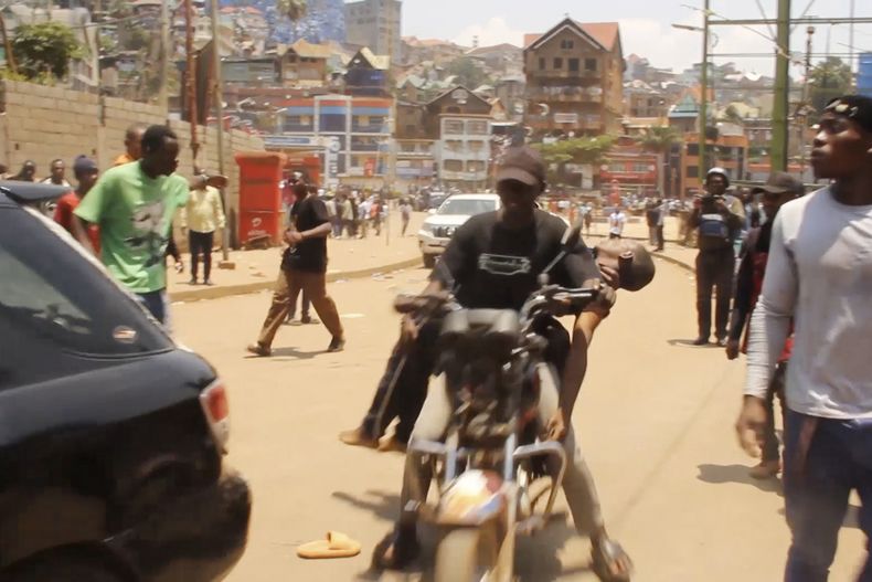 Foto tomada de video que muestra a gente ayudando a víctimas tras dos explosiones durante una reunión del grupo rebelde M23 en Bukavu, en el este del Congo, el 27 de febrero del 2025. (AP foto/Janvier Barhahiga)