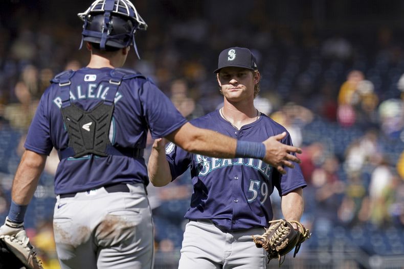 El lanzador relevista de los Marineros de Seattle, Troy Taylor, a la derecha, celebra con el receptor Cal Raleigh, a la izquierda, después de sacar el último out contra los Piratas de Pittsburgh, el domingo 18 de agosto de 2024, en Pittsburgh. (AP Foto/Matt Freed)