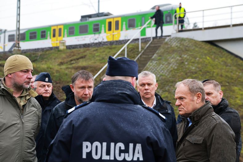 El primer ministro de Polonia, Donald Tusk (segundo por la derecha), visita el lugar donde se produjo una explosión en una vía ferroviaria luego de un sabotaje, en Mika, cerca de Deblin, Polonia, el 17 de noviembre de 2025. (AP Foto/KPRM)