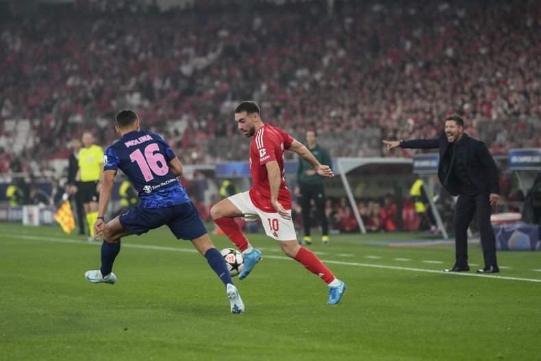 El técnico del Atlético de Madrid Diego Simeone da instrucciones a sus jugadores mientras Orkun Kokcu del Benfica pelea por el balón con Nahuel Molina del Atlético de Madrid en la Liga de Campeones el miércoles 2 de ocutbre del 2024. (AP Foto/Armando Franca)