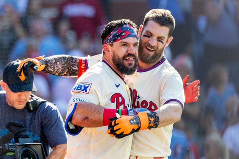 Kyle Schwarber, izquierda, y Bryce Harper, de los Filis de Filadelfia, celebran después de que Schwarber bateara el jonrón decisivo en la novena entrada del juego de béisbol de Grandes Ligas contra los Cardenales de San Luis, el domingo 23 de agosto de 2026, en Filadelfia. (AP Foto/Laurence Kesterson)