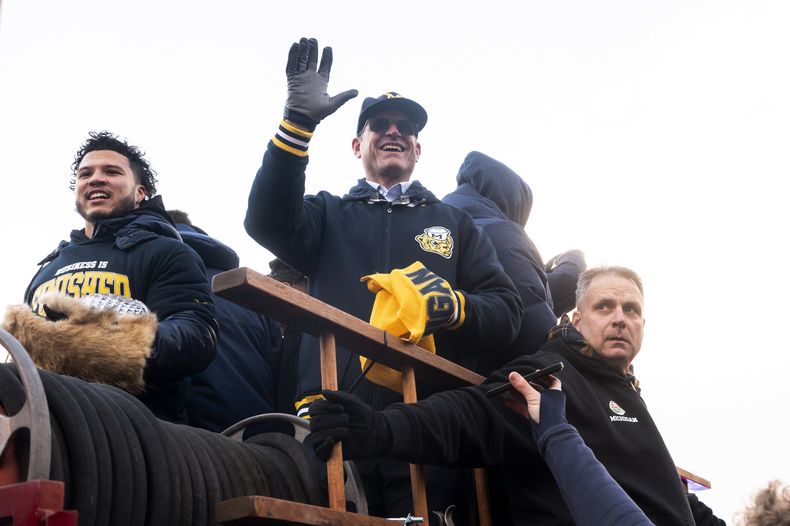 El coach Jim Harbaugh, de Michigan, saluda a los aficionados del equipo durante el desfile de celebración del campeonato nacional de los Wolverines de la Universidad de Michigan, en Ann Arbor, Michigan, el sábado 13 de enero de 2024. Harbaugh se entrevistó con los Chargers de Los Ángeles por la vacante de entrenador en jefe, informó el equipo de la NFL el lunes 15 de enero de 2024. (Jacob Hamilton/Ann Arbor News via AP)