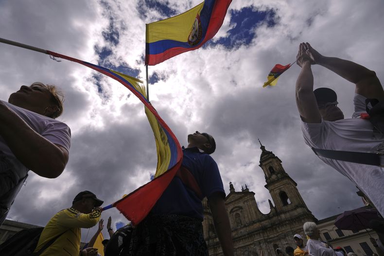 Manifestantes ondean banderas de Colombia para condenar el intento de asesinato contra el senador opositor Miguel Uribe Turbay, quien resultó herido en el ataque, el domingo 15 de junio de 2025, en Bogotá, Colombia. (Foto AP/Iván Valencia)