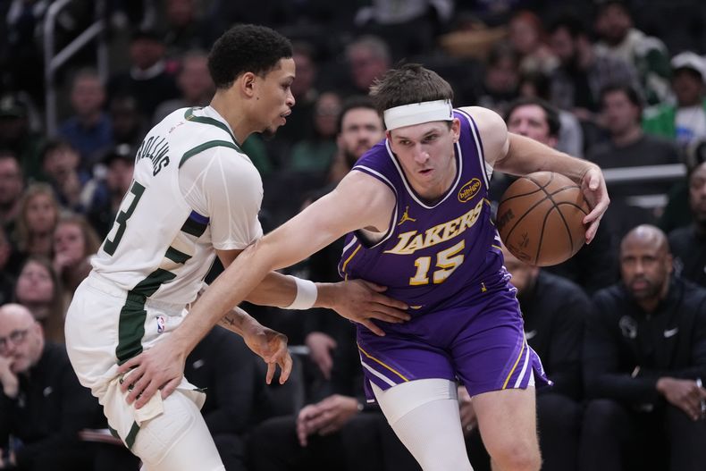 Austin Reaves, de los Lakers de Los Ángeles, elude a Ryan Rollins, de los Bucks de Milwaukee, en el duelo del sábado 15 de noviembre de 2025 (AP Foto/Morry Gash)