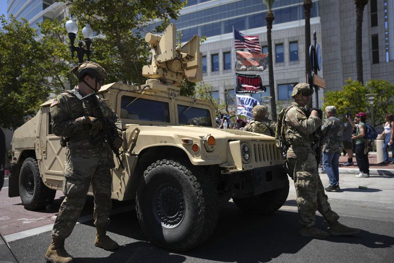 Soldados de la Guardia Nacional de California vigilan una calle cerca de manifestantes y simpatizantes de Trump en Santa Ana, California, el martes 10 de junio de 2025. (AP Foto Jae C. Hong)