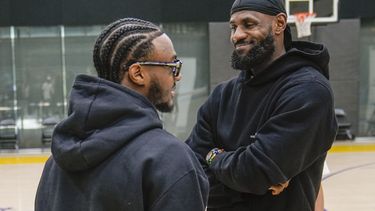 El recién seleccionado de los Lakers de Los Ángeles Bronny James habla con su padre LeBron James al llegar a la conferencia de prensa del equipo el martes 2 de julio del 2024. (AP Foto/Damian Dovarganes)