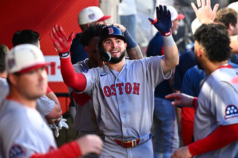 Wilyer Abreu, centro, de los Medias Rojas de Boston, es felicitado por sus compañeros de equipo después de anotar en la quinta entrada del juego de béisbol de Grandes Ligas ante los Angelinos de Los Ángeles, el sábado 4 de julio de 2026, en Anaheim, California. (AP Foto/William Liang)