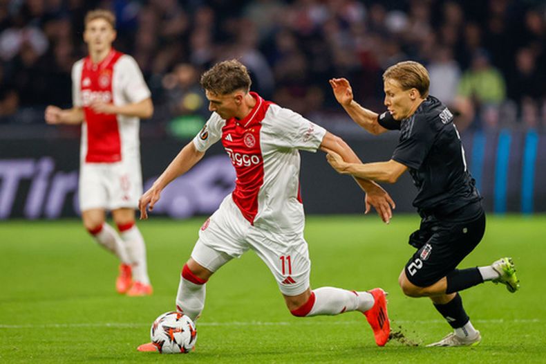 ARCHIVO - Mika Godts (izquierda) de Ajax pugna por el balón con Jonas Svensson de Besiktas en un partido de la Liga Europa, el jueves 26 de septiembre de 2024, en Amsterdam. (AP Foto/Maurice van Steen)