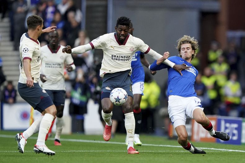 Todd Cantwell de los Rangers pelea por el balón frente a Ibrahim Sangare del PSV Eindhoven en el encuentro de playoff para la clasificación a la Liga de Campeones el martes 22 de agosto del 2023. (Andrew Milligan/PA via AP)