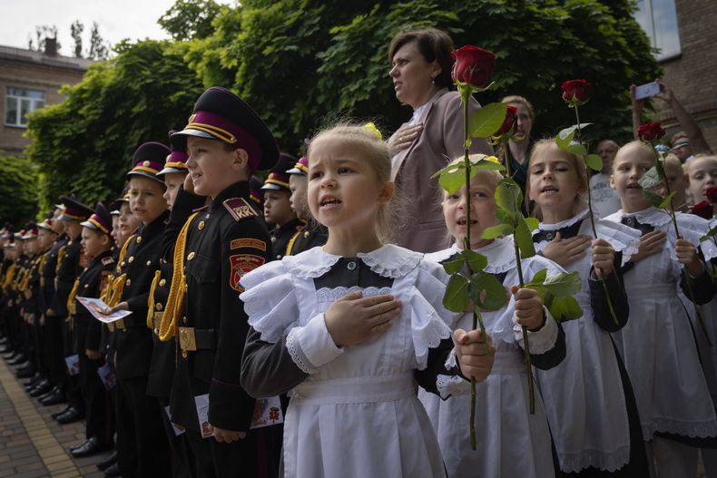 Jóvenes cadetes cantan el himno nacional durante una ceremonia de graduación en un liceo de cadetes en Kiev, Ucrania, el martes 13 de junio de 2023. (AP Foto/Efrem Lukatsky)